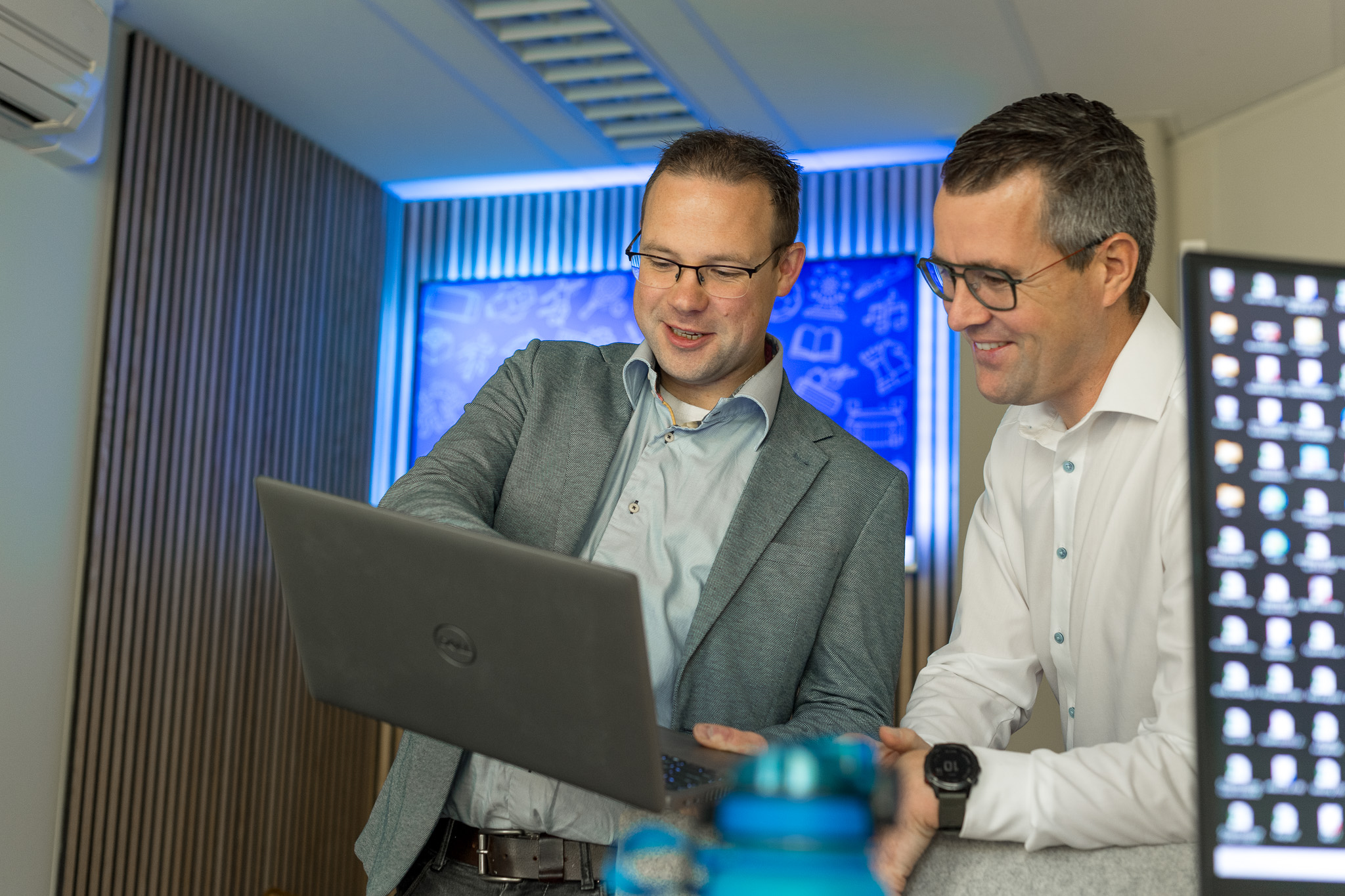 Twee collega's kijken naar informatie op een laptop