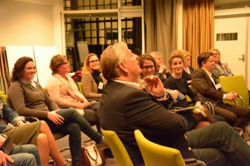 Deelnemers luisteren naar de les