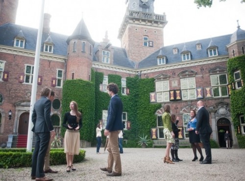 Deelnemers praten op het voorplein van het kasteel